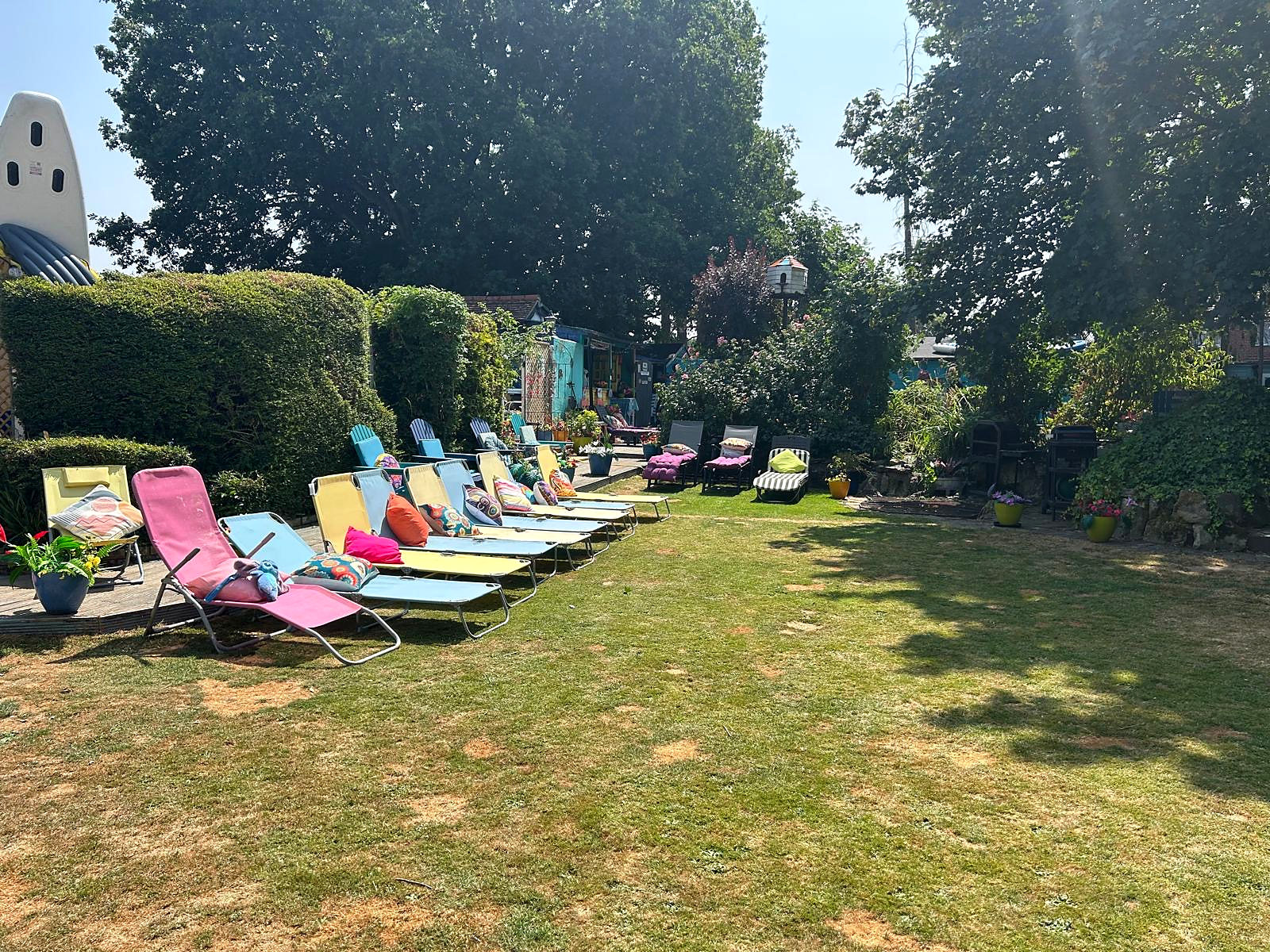 Wide view across Hazelwick's large guest garden with colourful loungers and seating