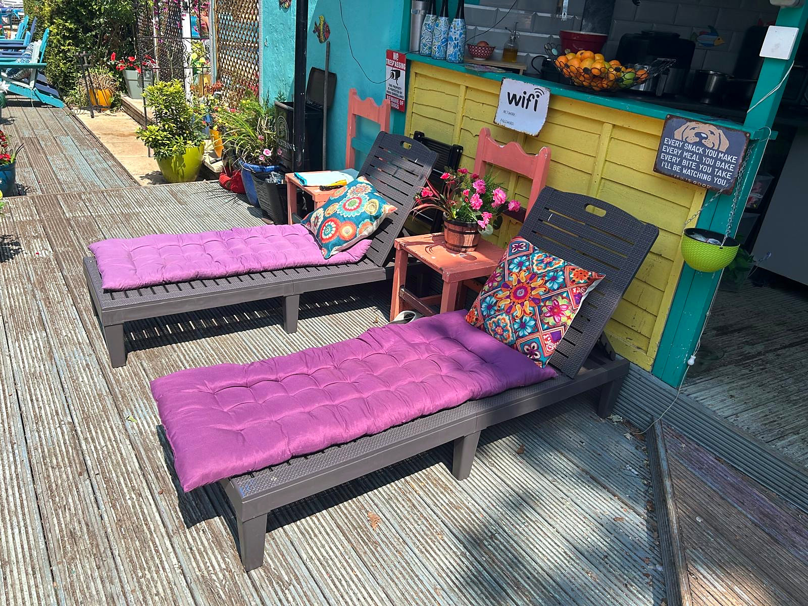 Colourful cushioned sun loungers beside Hazelwick's outdoor kitchen