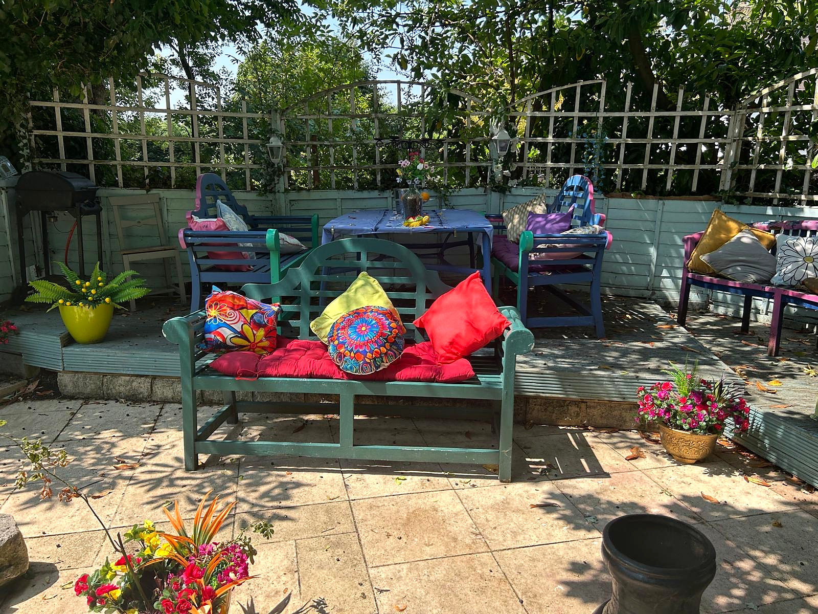 Shaded seating and dining area beneath the trees in Hazelwick's garden