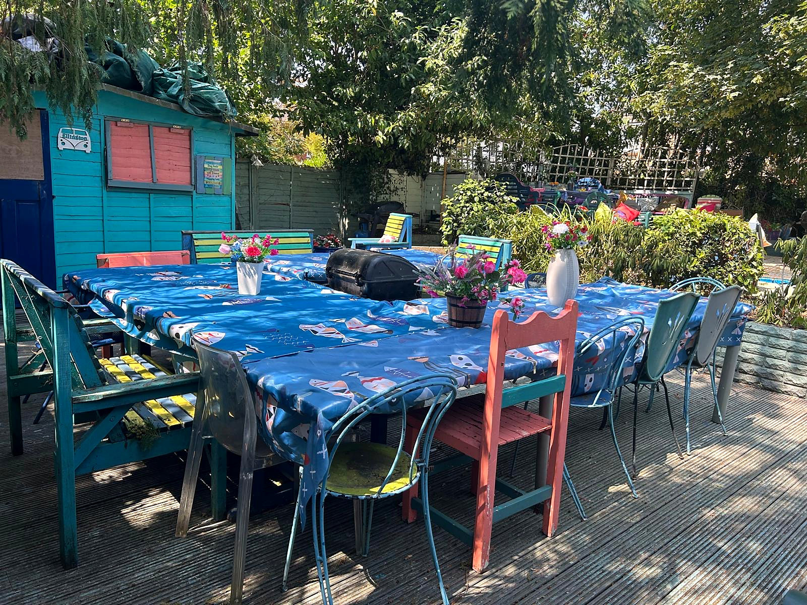 Large outdoor dining tables and colourful chairs in Hazelwick's garden